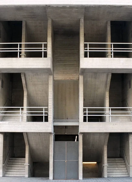 büyük bir modern binada birden fazla katlı ve korkulukları ile simetrik açısal brutalist beton merdivenler