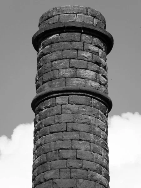 old stone mill chimney with sky and clouds