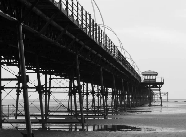 Southport pier showing beach and structure in the evening monoch — Stock Photo, Image