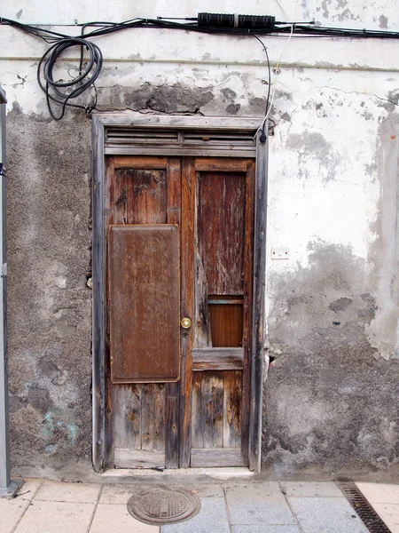 broken patched old brown door in rotten frame in an abandoned de