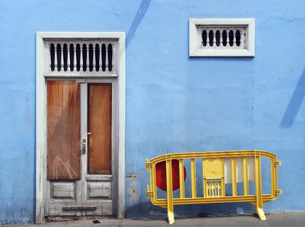 Brachliegendes verlassenes blaues Haus mit weißer kaputter Tür — Stockfoto