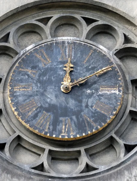 Viejo reloj torre iglesia erosionada en piedra tallada rodean con r — Foto de Stock