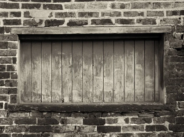 Janela encostada com tinta de descascamento em um prédio de tijolos velho — Fotografia de Stock