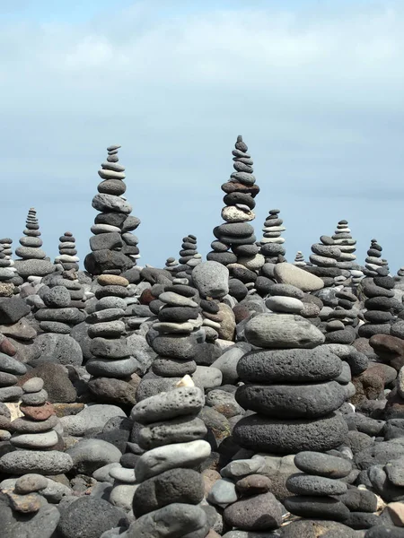 Rotskunst palen en torens van grijze stenen en kiezels op een strand — Stockfoto