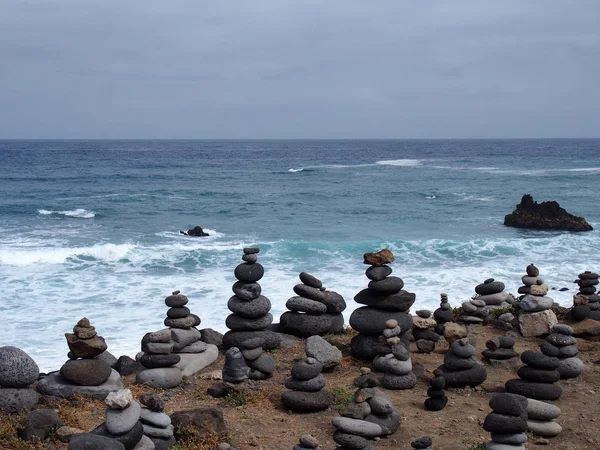 成堆的堆积的石头在海滩上与冲浪波和蓝天 — 图库照片