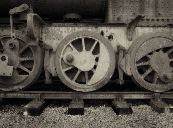 Wielen van een vintage vernielde stoommachine roestig in sepia — Stockfoto