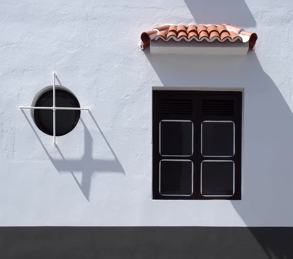 White painted building with round and square window with shutter — Stock Photo, Image