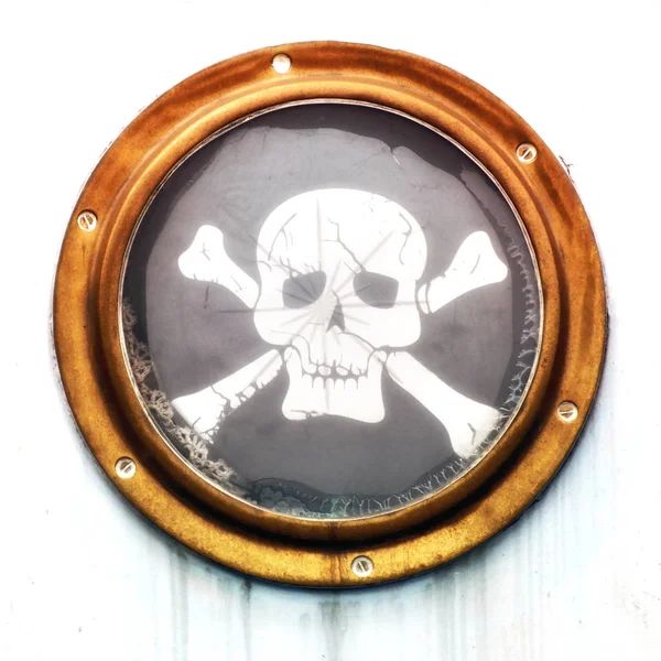 Hublot vintage en laiton avec drapeau pirate sur un bateau rouillé — Photo