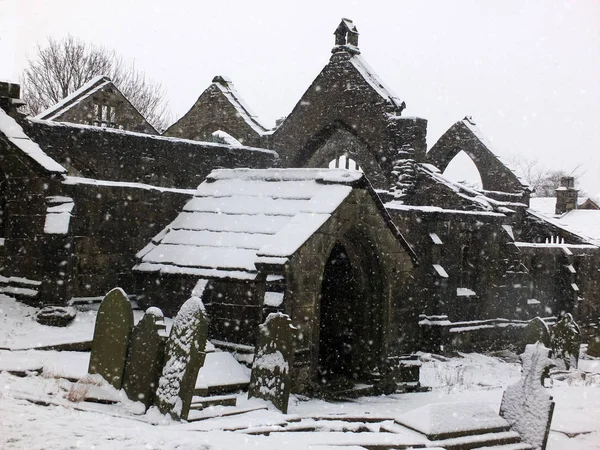 Pittoreske verwoeste kerk in vallende sneeuw in Heptonstall met gr — Stockfoto