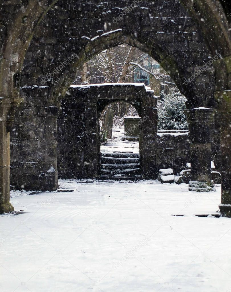 ruined church in snowfall with doorway and arches in heptonstall