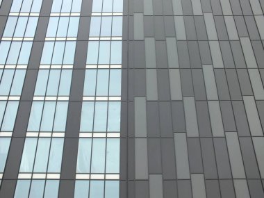 dikdörtgen gri kaplama ve dikey pencereler ile modern highrise bina 