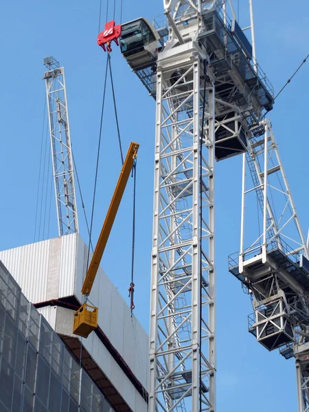 Detalle de una grúa de construcción grande levantando una gran viga metálica — Foto de Stock