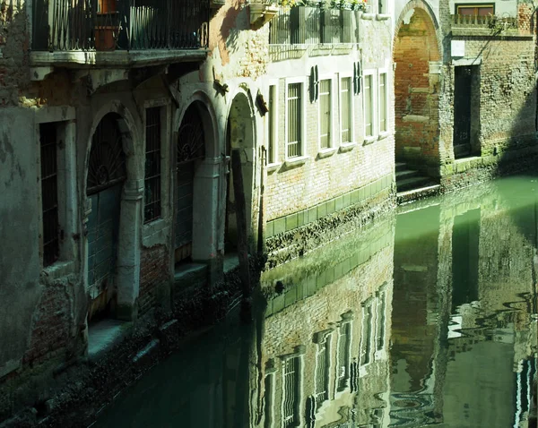 Canal em veneza com reflexos de edifícios portas de paredes antigas e — Fotografia de Stock