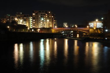 gece Leeds nehir Aire Crown Point Köprüsü her iki tarafında binalar gösteren ve Weir