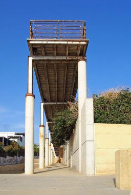 bir güneş ışığı mavi gökyüzü ile Baf Kıbrıs 'ta metal korkulukları ve Beton sütunlar ile eski bir paslama terk iskele