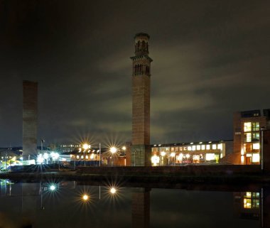 Güney Leeds 'de Holbeck 'in Cityscape görünümü, tarihi kuleyi gösteren ofis binası ile geceleri çalışır ve kanala yansıyan ışıklar