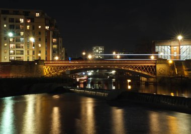 Çevredeki ışıklar ve binalar ile geceleri nehir Aire genelinde taç noktası yol Köprüsü trafiğe geçen su ve hafif yollar yansıyan.