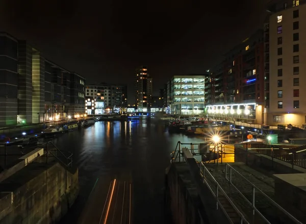 Vista sul paesaggio urbano della darsena di Clarence a Leeds di notte che mostra le porte della serratura e l'acqua circondata da edifici — Foto Stock