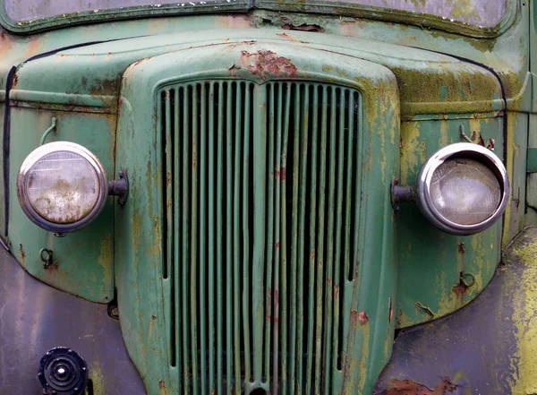 Cerca de la parte delantera de un viejo camión verde oxidado abandonado co — Foto de Stock