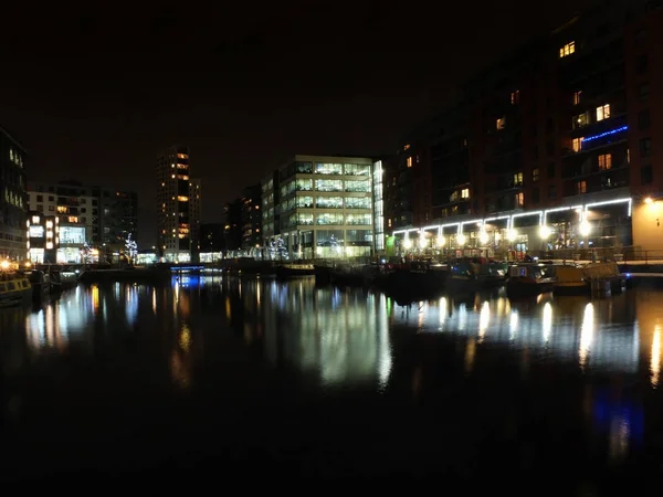 Uma vista de clarence dock em leeds à noite com edifícios à beira-mar e luzes refletidas na água — Fotografia de Stock