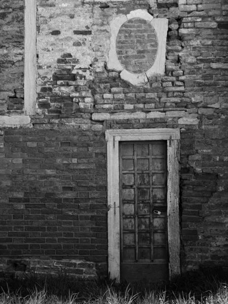 Antigua pared de ladrillo con ventanas y puertas bloqueadas — Foto de Stock