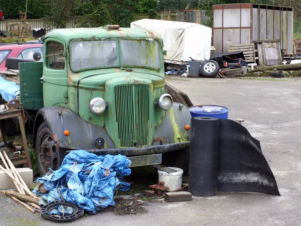 Un vieux camion rouillé avec des débris de bois et de métal dans un dépotoir rural — Photo