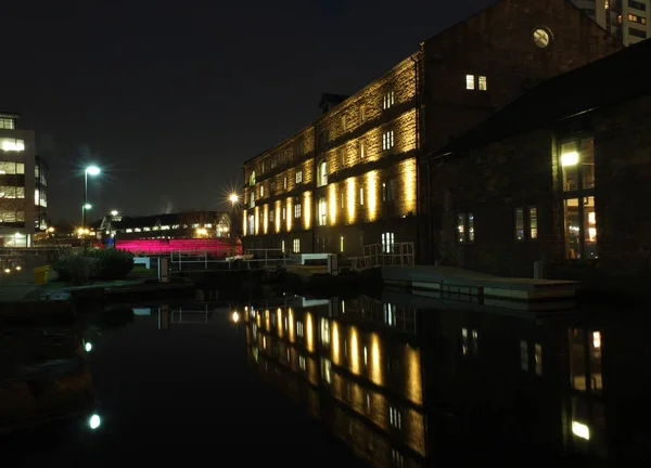 Nummer een slot op de Leeds Canal 's nachts in de buurt van graanschuur met Victoria Bridge en verlichte gebouwen weerspiegeld in het water — Stockfoto