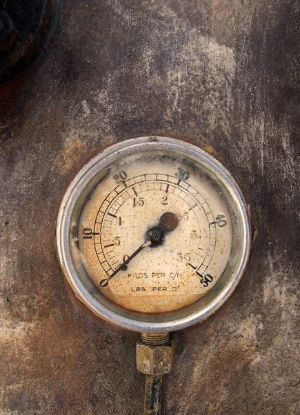 An old round pressure meter with numbers on the gauge on a rusty metal background — Stock Photo, Image