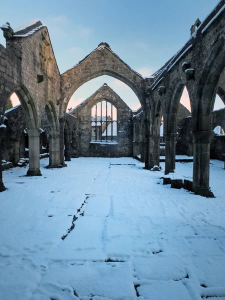 La iglesia medieval en ruinas en heptonstall cubierto de nieve que muestra arcos y columnas contra un cielo azul de invierno —  Fotos de Stock