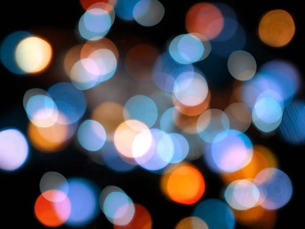 Niebieskie i pomarańczowe okrągłe świecące niewyraźne światła na czarnym rynek — Zdjęcie stockowe