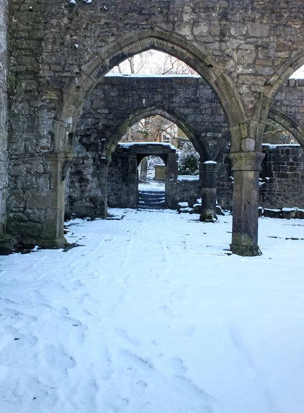 Arcos y columnas en la iglesia medieval en ruinas en Hebden puente oeste de Yorkshire con nieve cubriendo el suelo en invierno —  Fotos de Stock