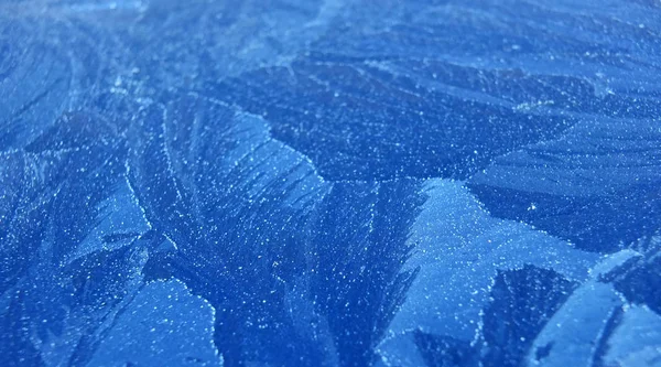 Escarcha y hielo formando patrones abstractos sobre una superficie pintada de azul — Foto de Stock