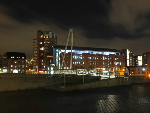 Вход на рыцарский мост, пересекающий реку Эр в Лидсе ночью с городской квартирой и офисными зданиями ярко освещенными — стоковое фото