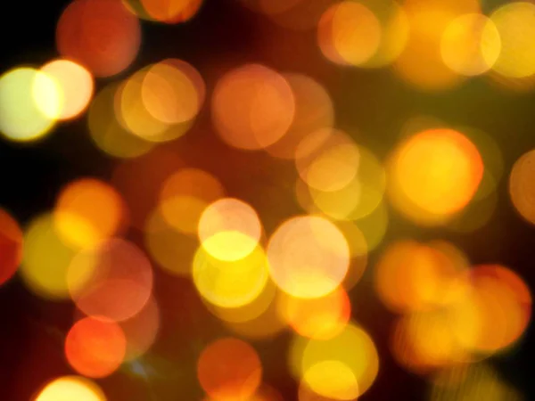 Bright golden orange glowing blurred lights shining night abstra — Stock Photo, Image