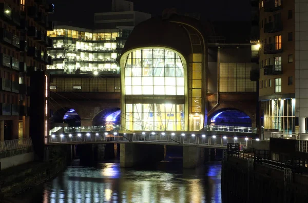 A cityscape night view of leeds showing the river aire running under the dark arches and the southern entrance to the station surrounded by illuminated office developments — Stock Photo, Image