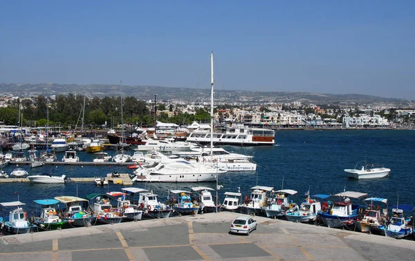 Widok z lotu ptaka łodzi rybackich i jachtów zacumowany w porcie w Pafos z budynków post i miasta w oddali — Zdjęcie stockowe