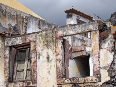 close up of the windows of a collapsing abandoned roofless house with broken shutter and grey sky clipart