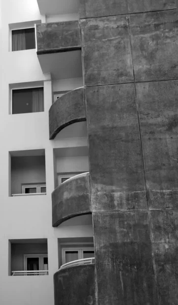 Varandas curvas e janelas quadradas em um prédio de apartamentos de concreto manchado velho — Fotografia de Stock