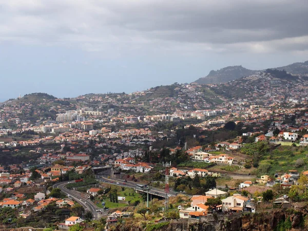 Funchal, Madeira, Portugalsko-17. března 2019: výhled na silnice a domy na Funchalu Madeira s pozadím s šedými mraky a horami — Stock fotografie