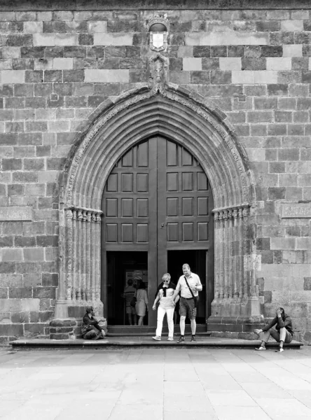 Des gens devant la porte de la cathédrale funchale de Madère avec des mendiants assis dehors sur les marches — Photo