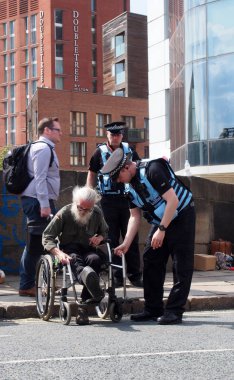 leeds, west yorkshire, united kingdom - 16 july 2019: police liaison officers helping man in wheelchair at extinction rebellion protest blocking road at victoria bridge in leeds clipart