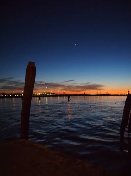 Night Venice Lagoon Med Förtöjnings Stolpar Silhouette Stadsljus Reflekteras Havet — Stockfoto