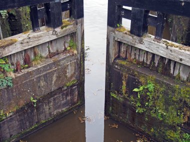 Batı Yorkshire 'daki Calder ve Hebble navigasyon kanallarında tekneler ve demirlemelerle aydınlık havzanın kilit girişinin manzarası.
