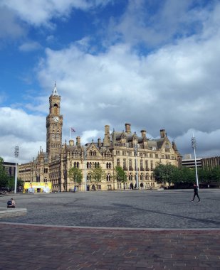 Bradford Batı Yorkshire 'daki 100. meydanda belediye binasının önünden geçen ve saray binalarına hakim olan insanlar var.