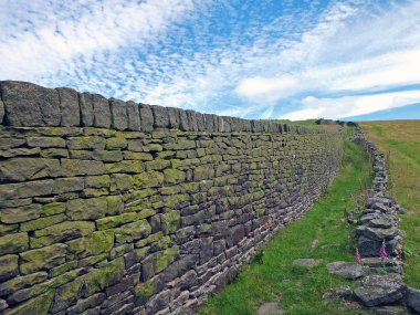 Yorkshire Dales kırsalındaki çimenleri beyaz bulutlarla kaplı Calderdale 'deki soğuk ve Heptonstall arasında ayıran geniş bir kuru taş duvar boyunca perspektif manzarası