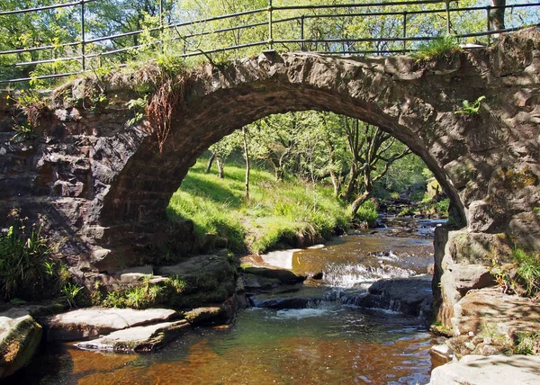 Die alte packhorse bridge am lumb hole fällt bei crimsworth dean in der nähe von pecket well in calderdale west yorkshire ein wasserfall — Stockfoto