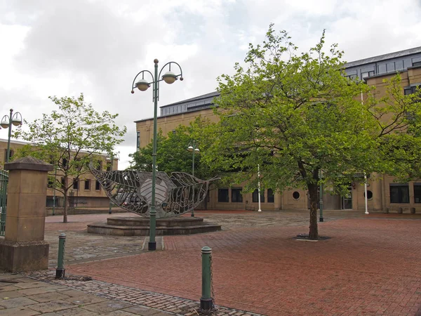 A view of exchange square in bradford west yorkshire with the crown court building surrounded by trees — Stock Photo, Image