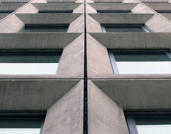 Geometrik açılı beton pencerelere bakış açısı modernist 1960 'ların vahşi tarzı binasının ön cephesinde — Stok fotoğraf