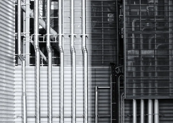 Tubi in acciaio lucido che scorrono lungo un edificio industriale in metallo — Foto Stock