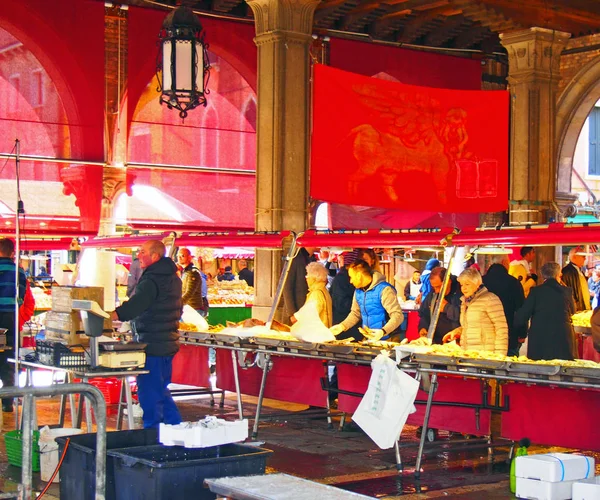 Peixeiros e pessoas que fazem compras no mercado de peixe histórico na área de rialto de Veneza — Fotografia de Stock